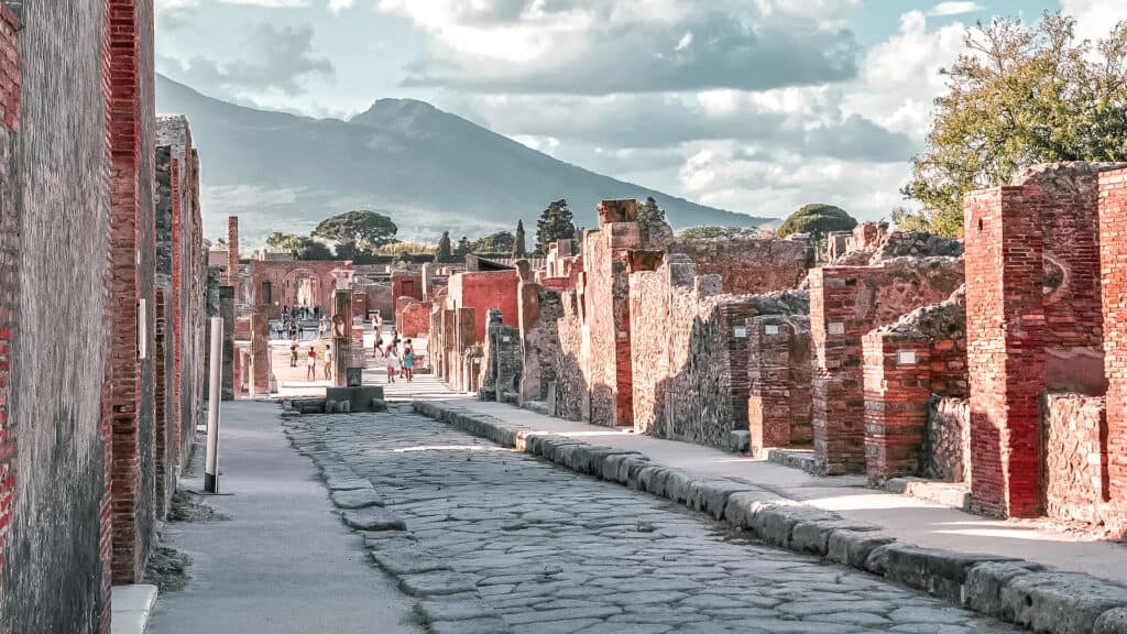 street of pompeii and behind is mount Vesuvius 