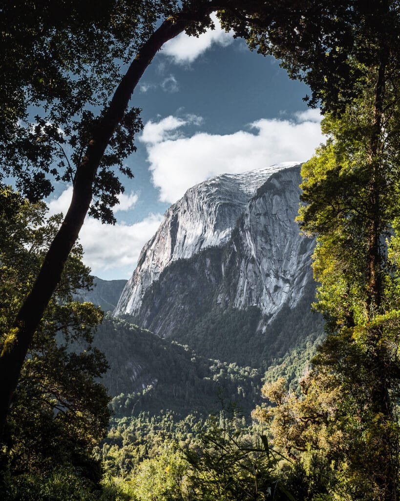 A mountain surrounded by trees that create a frame for the image
